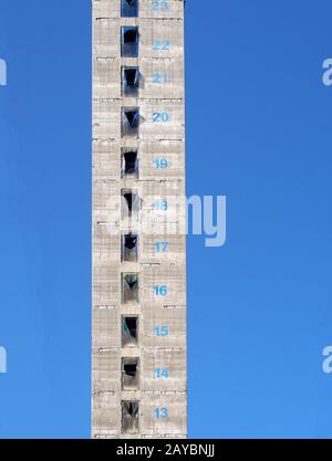 a tall concrete structure and service core of a new skyscraper building under construction with floor numbers marked in paint ag Stock Photo