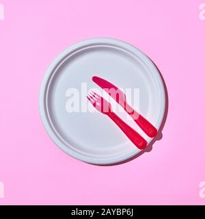 Served place with disposable plastic utensils on pink. Stock Photo