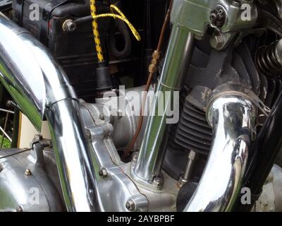 close up of the engine and frame on an vintage motorbike with black cylinders and chrome pipes Stock Photo