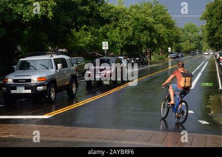 Spruce Street in Boulder when the sun comes out after a summer rain. Bikers are out in Boulder during just about any weather. Stock Photo