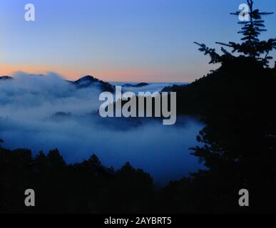 Fog settles between peaks in Rocky Mountains west of Boulder, CO Stock Photo