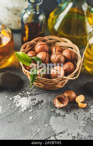 Natural macadamia oil in a glass bottle with macadamia nuts Stock Photo