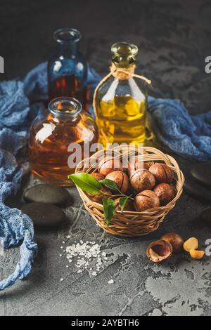Natural macadamia oil in a glass bottle with macadamia nuts Stock Photo