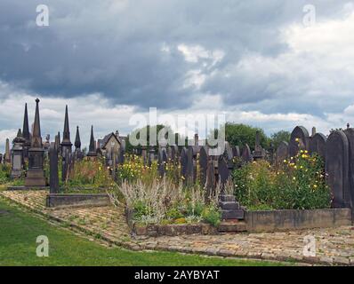 19th century gothic styled gravestones surrounded by wildflowers in the former lister cemetery in halifax now a public park Stock Photo