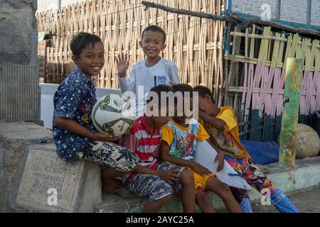 A village scene with local boys in the Bajau Sea Gypsy village on Bungin Island, famous for living in stilt houses above the water and living entirely Stock Photo