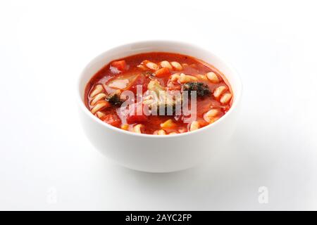 minestrone vegetables tomato soup with pasta closeup isolated on white background Stock Photo