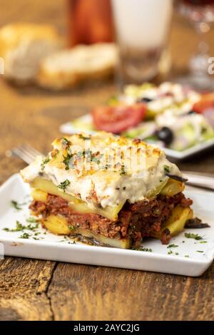 Greek salad with moussaka on wood Stock Photo