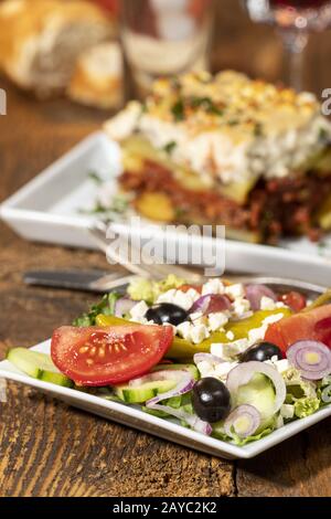 Greek salad with moussaka on wood Stock Photo