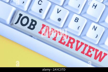 Text sign showing Job Interview. Conceptual photo Assessment Questions Answers Hiring Employment Panel White pc keyboard with em Stock Photo