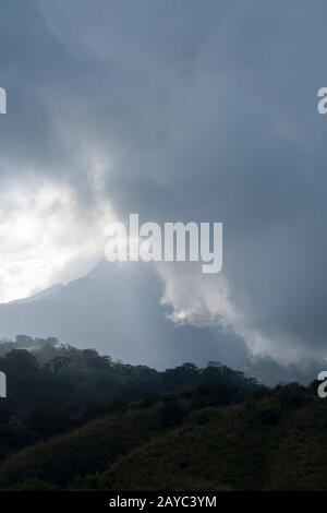 View of Sangeang Api Volcano Island near Sumbawa Island, Lesser Sunda Islands, Indonesia, with the volcano covered by clouds. Stock Photo