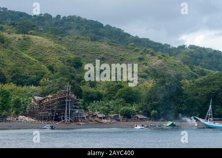 View of a very large pinisi boat being built on the beach at Sangean village, Sangeang Api Volcano Island near Sumbawa Island, Lesser Sunda Islands, I Stock Photo