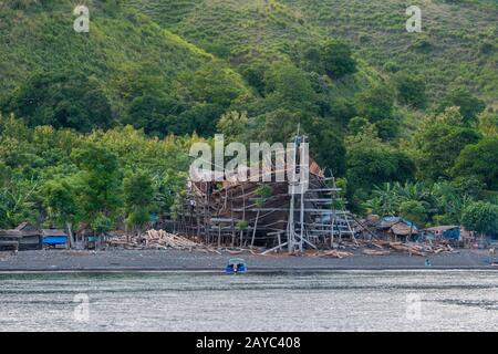 View of a very large pinisi boat being built on the beach at Sangean village, Sangeang Api Volcano Island near Sumbawa Island, Lesser Sunda Islands, I Stock Photo