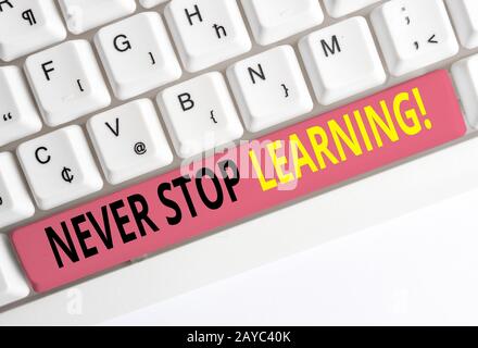 Handwriting text Never Stop Learning. Concept meaning keep on studying gaining new knowledge or materials White pc keyboard with Stock Photo