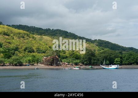 View of a very large pinisi boat being built on the beach at Sangean village, Sangeang Api Volcano Island near Sumbawa Island, Lesser Sunda Islands, I Stock Photo