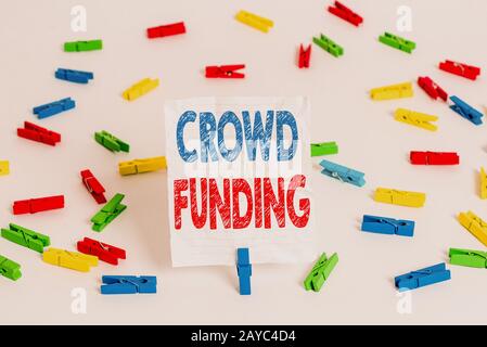 Text sign showing Crowd Funding. Conceptual photo Fundraising Kickstarter Startup Pledge Platform Donations Colored clothespin p Stock Photo