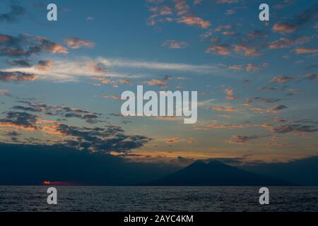 View at sunset from the distance of Sangeang Api Volcano Island near Sumbawa Island, Lesser Sunda Islands, Indonesia. Stock Photo