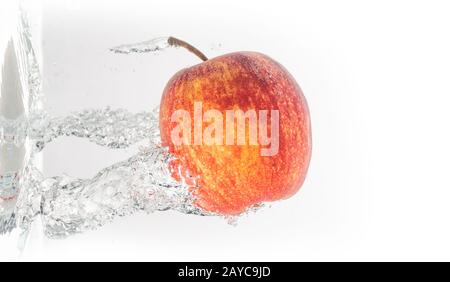 Apple falls under water with a splash from left side Stock Photo