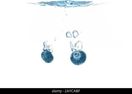Two blueberry’s splashing into crystal clear water Stock Photo