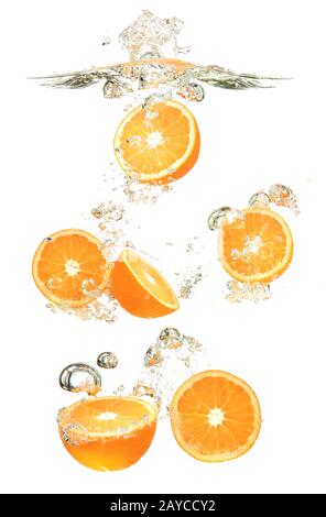 Oranges fruits dropped into water splash on white background Stock Photo