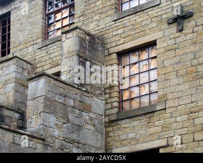an old abandoned factory building with boarded up and broken windows Stock Photo