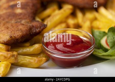 Wiener Schnitzel with French fries on the plate Stock Photo