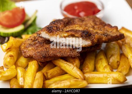 Wiener Schnitzel with French fries on the plate Stock Photo