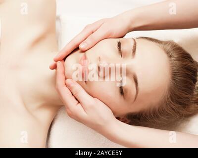 Spa. Woman enjoying anti-aging facial massage Stock Photo