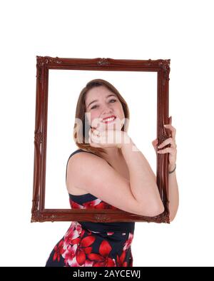 Beautiful woman looking trough a picture frame Stock Photo