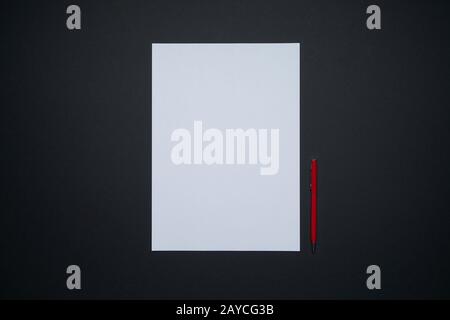 White sheet paper and red pen isolated on black background Stock Photo