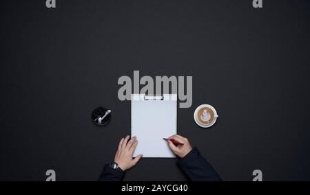 Businessman hands writing on white paper . Flat lay and top view with copy space on black background .business desk  lifestyle c Stock Photo