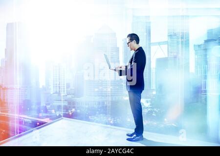 Businessman using laptop with generic office background Stock Photo
