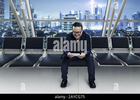 Young smiling businessman sitting at conference room and using smart phone Stock Photo