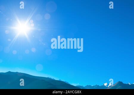 Blue sky with sunny sun and mountain. Stock Photo