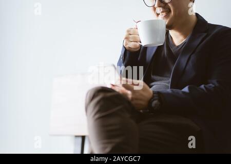 Coffee in businessman hand with with smartphone Stock Photo