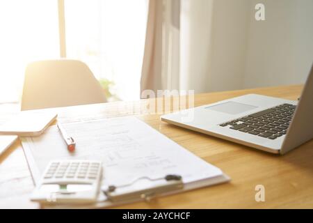 Wide angle perspective view of office workplace with laptop and smart phone on wood table with window . Stock Photo