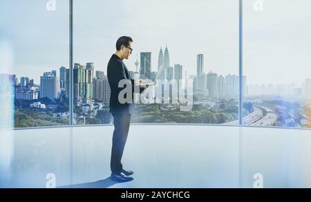 Businessman using laptop with generic office background Stock Photo