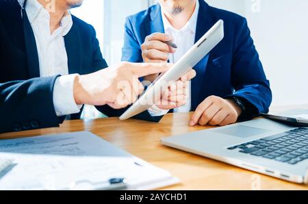 Two businessman using digital tablet to discuss finance and marketing solution . Stock Photo