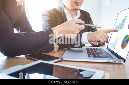 Two businessmen discussing the charts and graphs showing the results of their successful project .Digital tablet Stock Photo