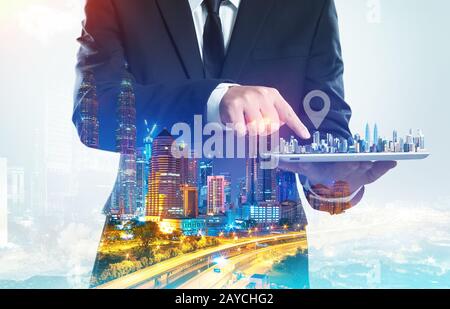 Success businessman using digital tablet show the home on virtual screen with night cityscape double exposure effect  . Stock Photo