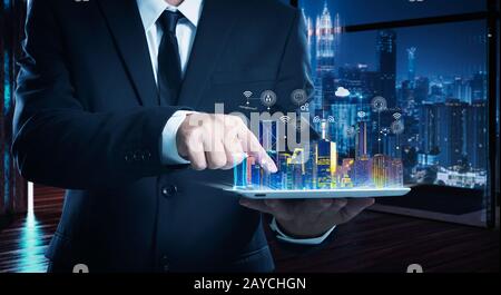 Businessman working on digital table with intelligence iot and smart city showing on virtual screen . Stock Photo