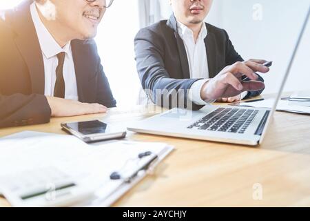 Two businessman using laptop to discuss finance and marketing solution . Stock Photo