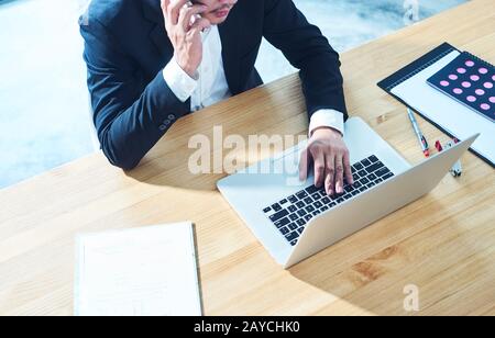 Top angle view of businessman using smart phone and laptop  to working at office . Stock Photo