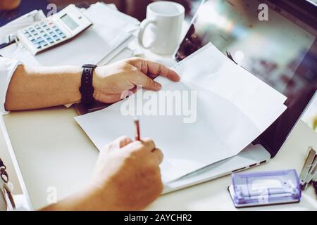 Businessman holding a pen for working on his plan project Stock Photo