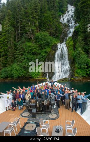 Passengers on the bow of the cruise ship Safari Endeavour in front of a waterfall in Red Bluff Bay on Baranof Island, Tongass National Forest, Alaska, Stock Photo