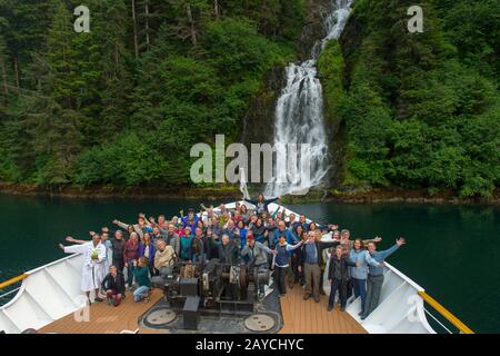 Passengers on the bow of the cruise ship Safari Endeavour in front of a waterfall in Red Bluff Bay on Baranof Island, Tongass National Forest, Alaska, Stock Photo