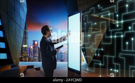 Smart businessman touch the screen to search the information of intelligent communication network of things . Night scene with m Stock Photo