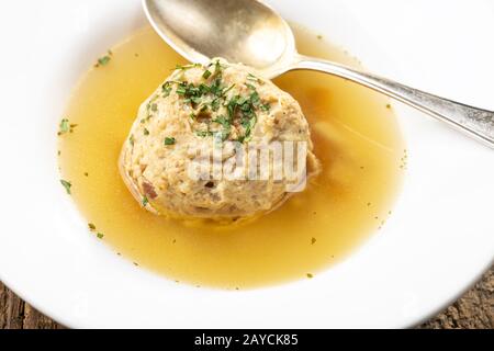 single bacon dumpling in soup on wood Stock Photo