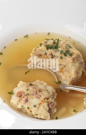 single bacon dumpling in soup on wood Stock Photo