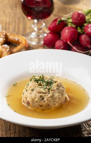 single bacon dumpling in soup on wood Stock Photo