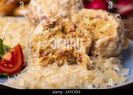 two bacon dumplings with sauerkraut on wood Stock Photo